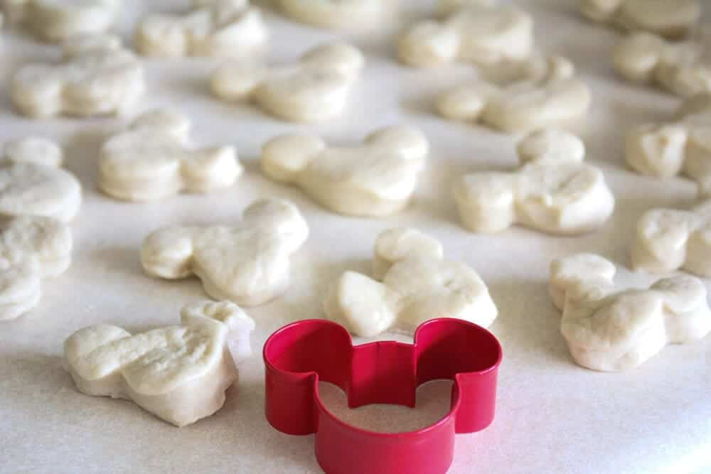 Cutting out beignets with a mickey mouse cutter.