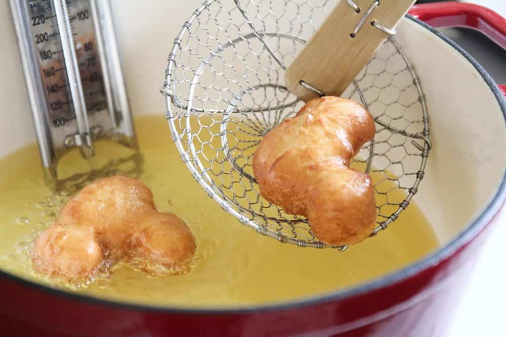 Removing mickey beignet from oil.