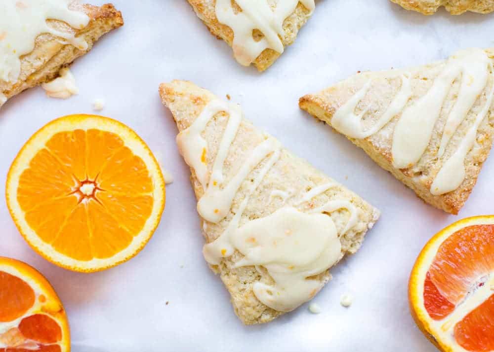 Orange scones drizzled with glaze on top.
