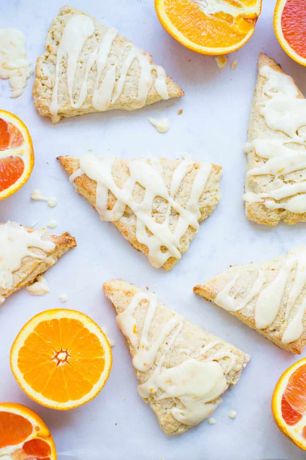 Glazed orange scones on a white counter.