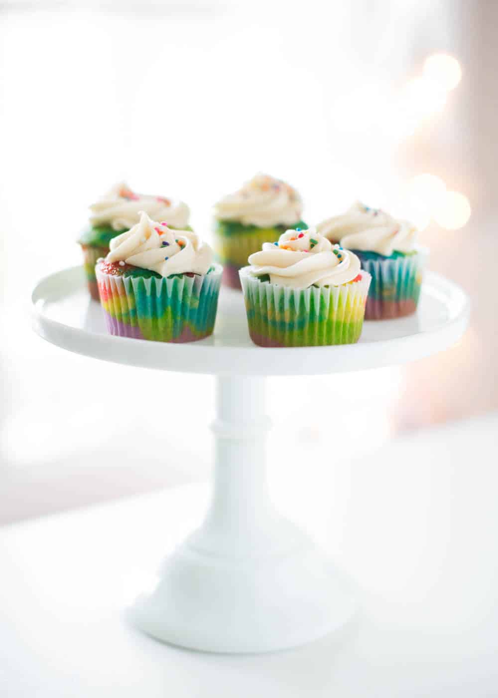 rainbow cupcakes on cake stand