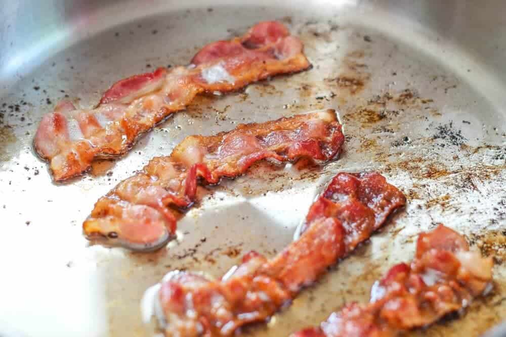 Cooking bacon on skillet.