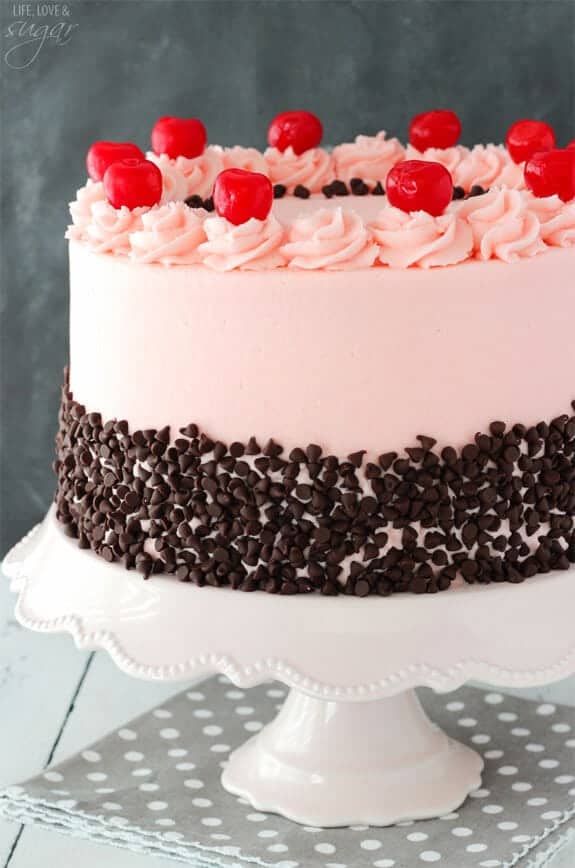 cherry chocolate chip cake on a white cake stand 