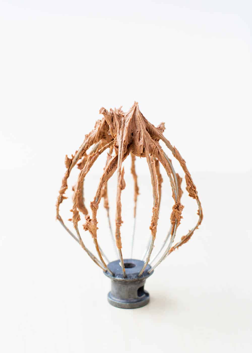 Chocolate frosting on a kitchen aid wire whisk. 