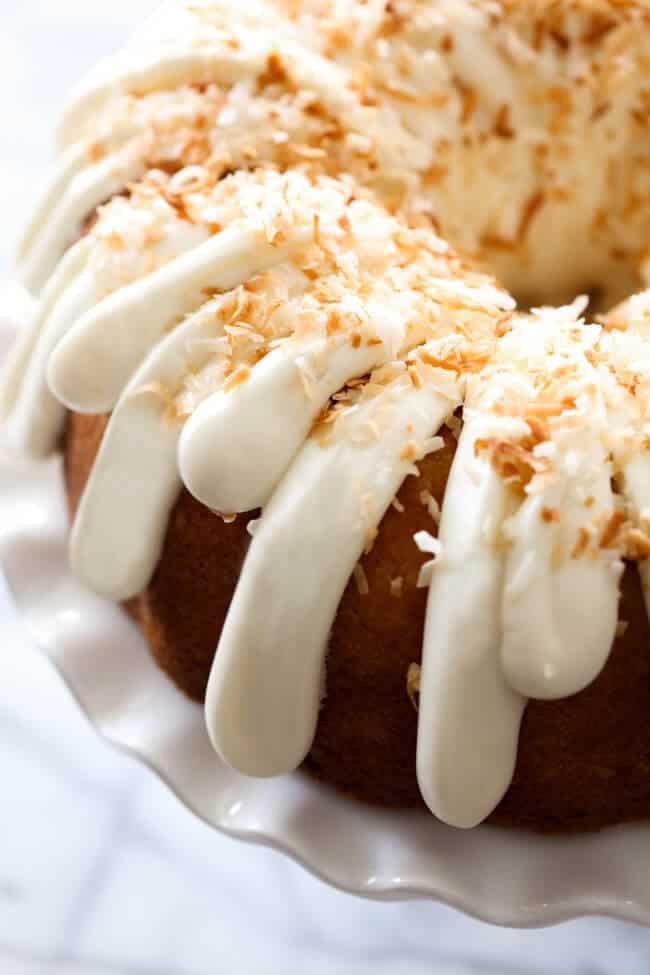 A close up of a frosted coconut bundt cake 