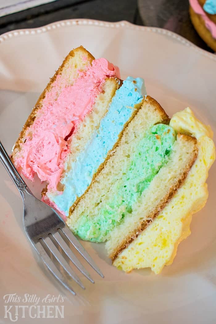 piece of rainbow cake on a plate with fork 