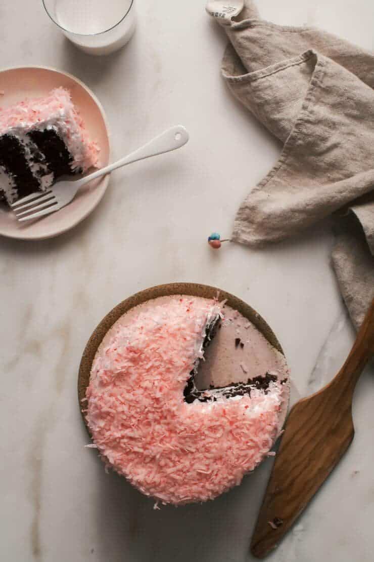 pink coconut cake with a slice taken out 