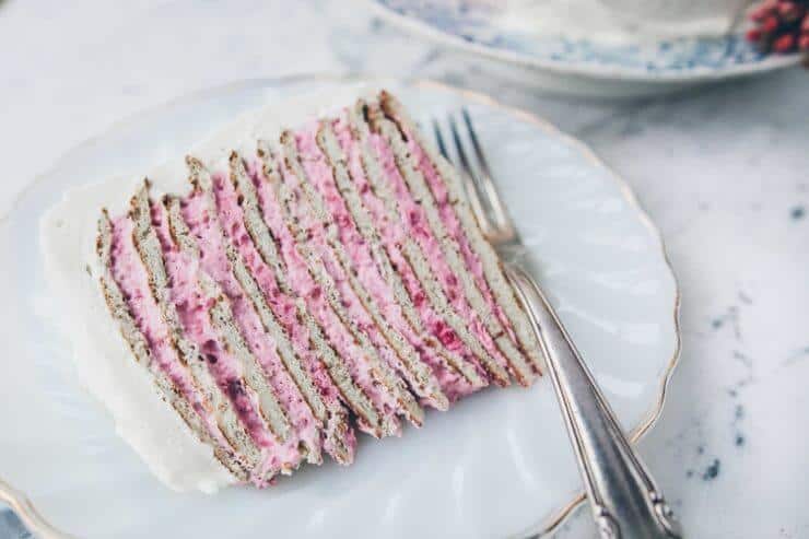 piece of almond crepe cake with raspberry frosting on a plate 