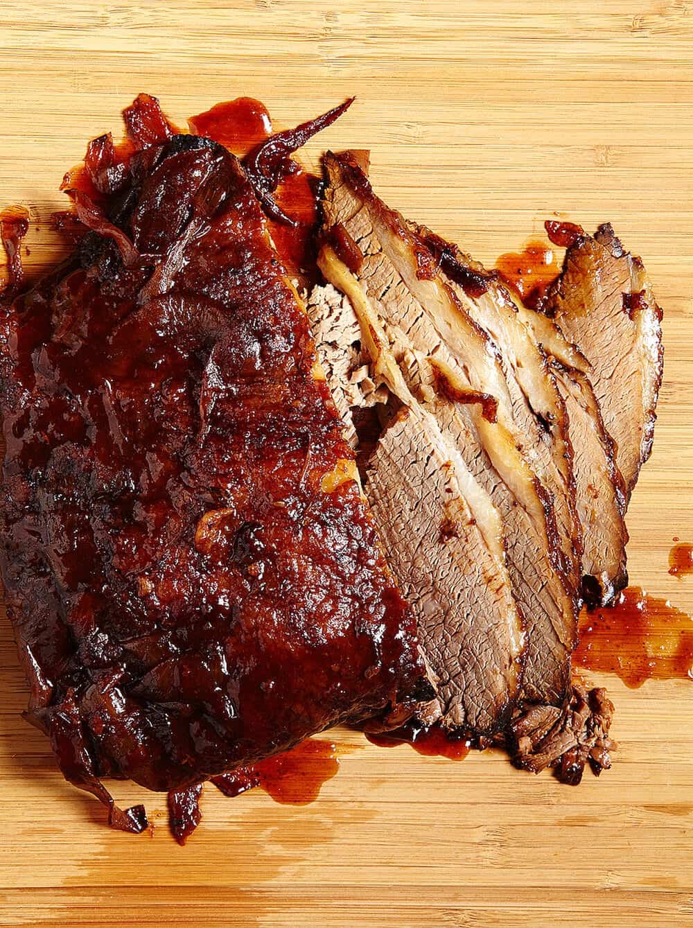 Sliced bbq beef brisket on a cutting board.