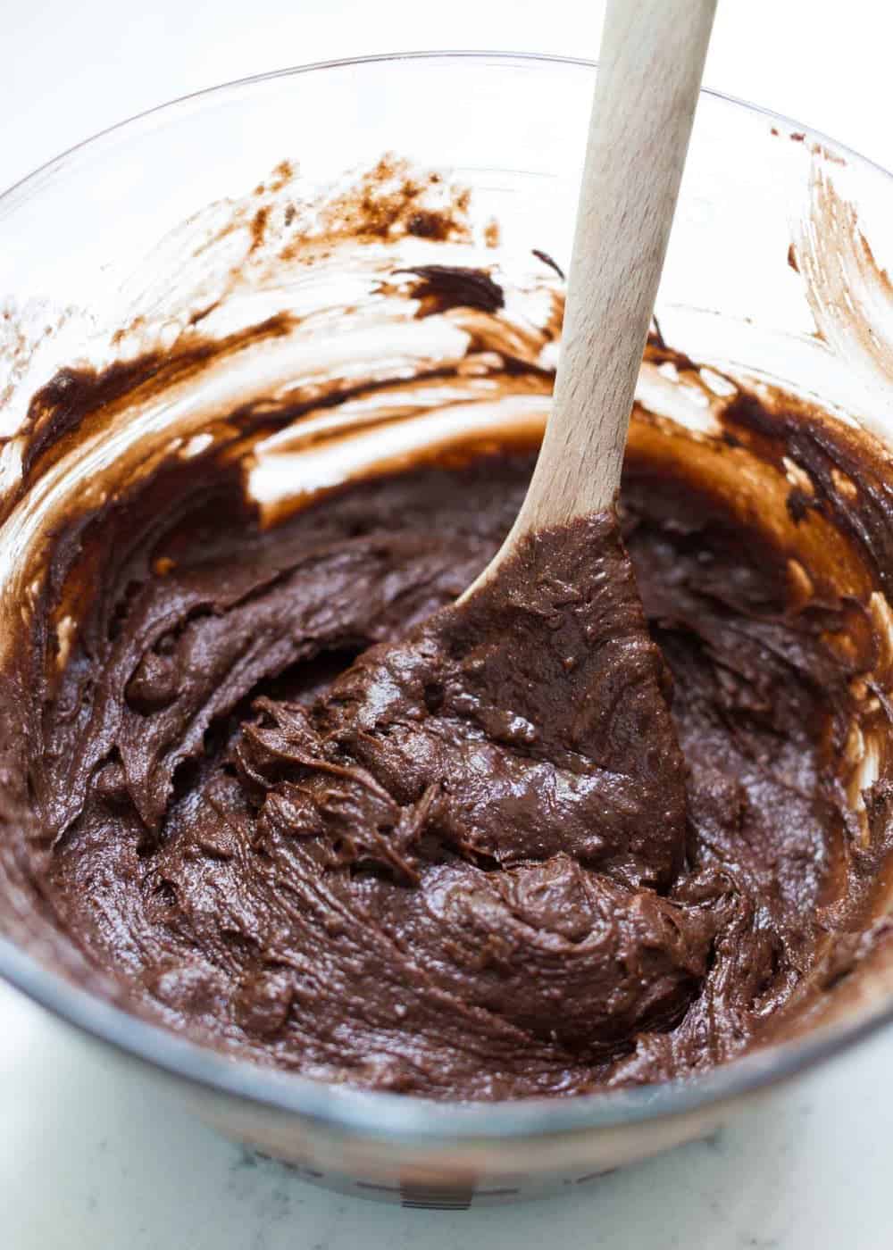 Mixing brownie batter with wooden spoon.