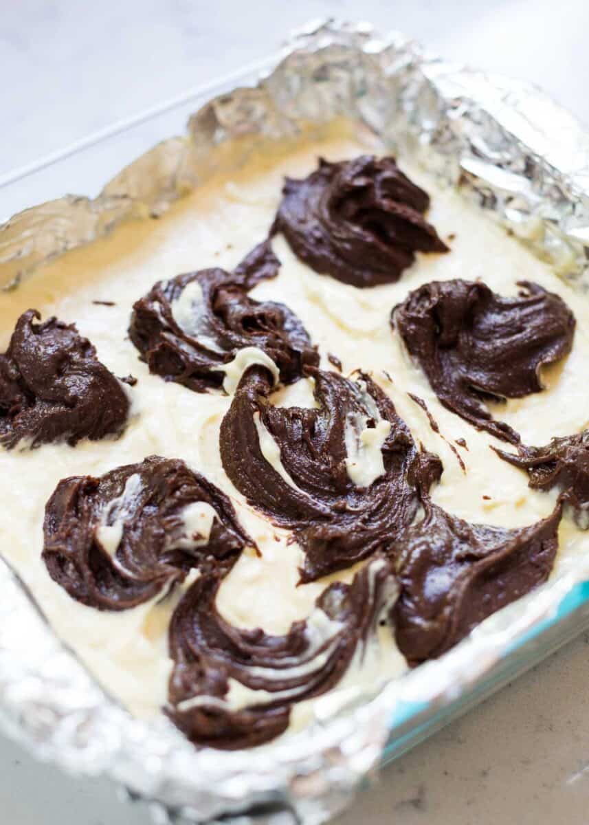 swirling the cheesecake brownie layers together 