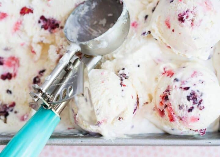 scooping out no churn ice cream with berries 