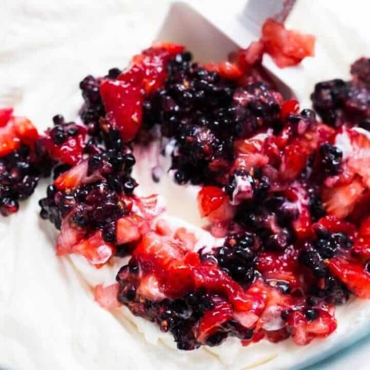 mixing smashed berries into no churn ice cream 