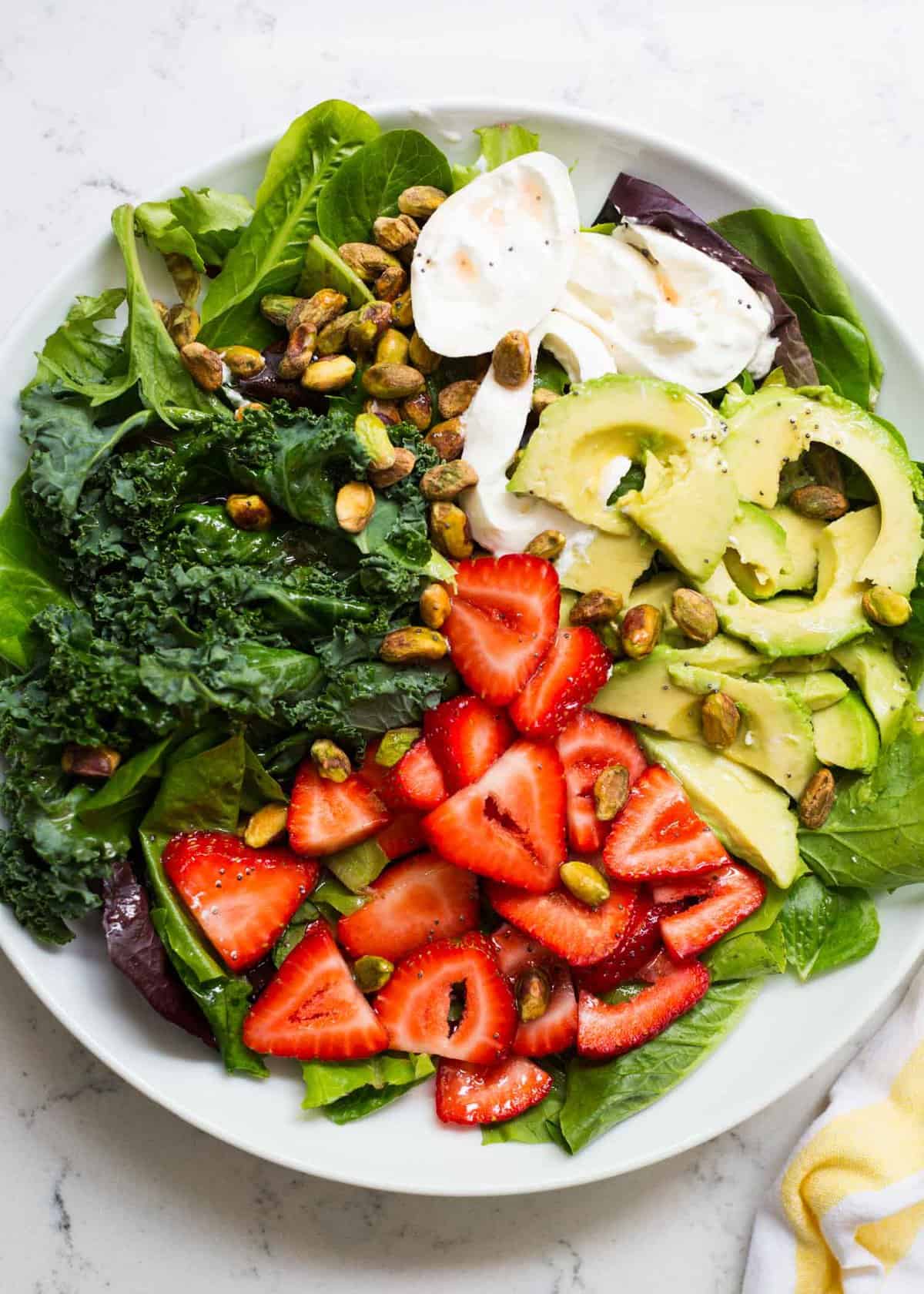 Strawberry burrata salad on white plate.