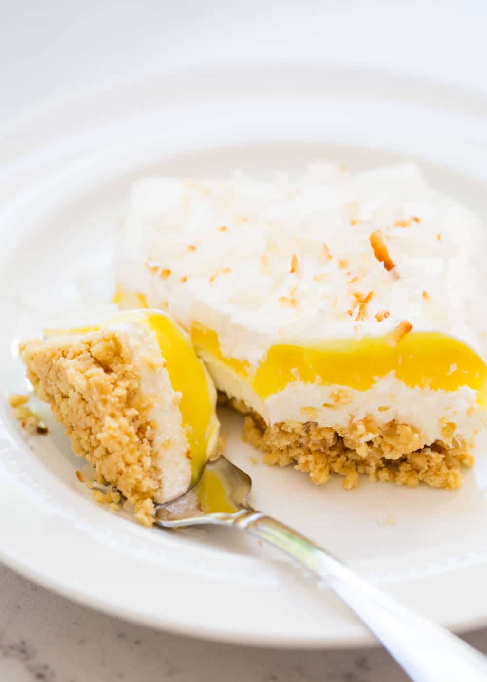 Lemon lasagna on a white plate with a fork.