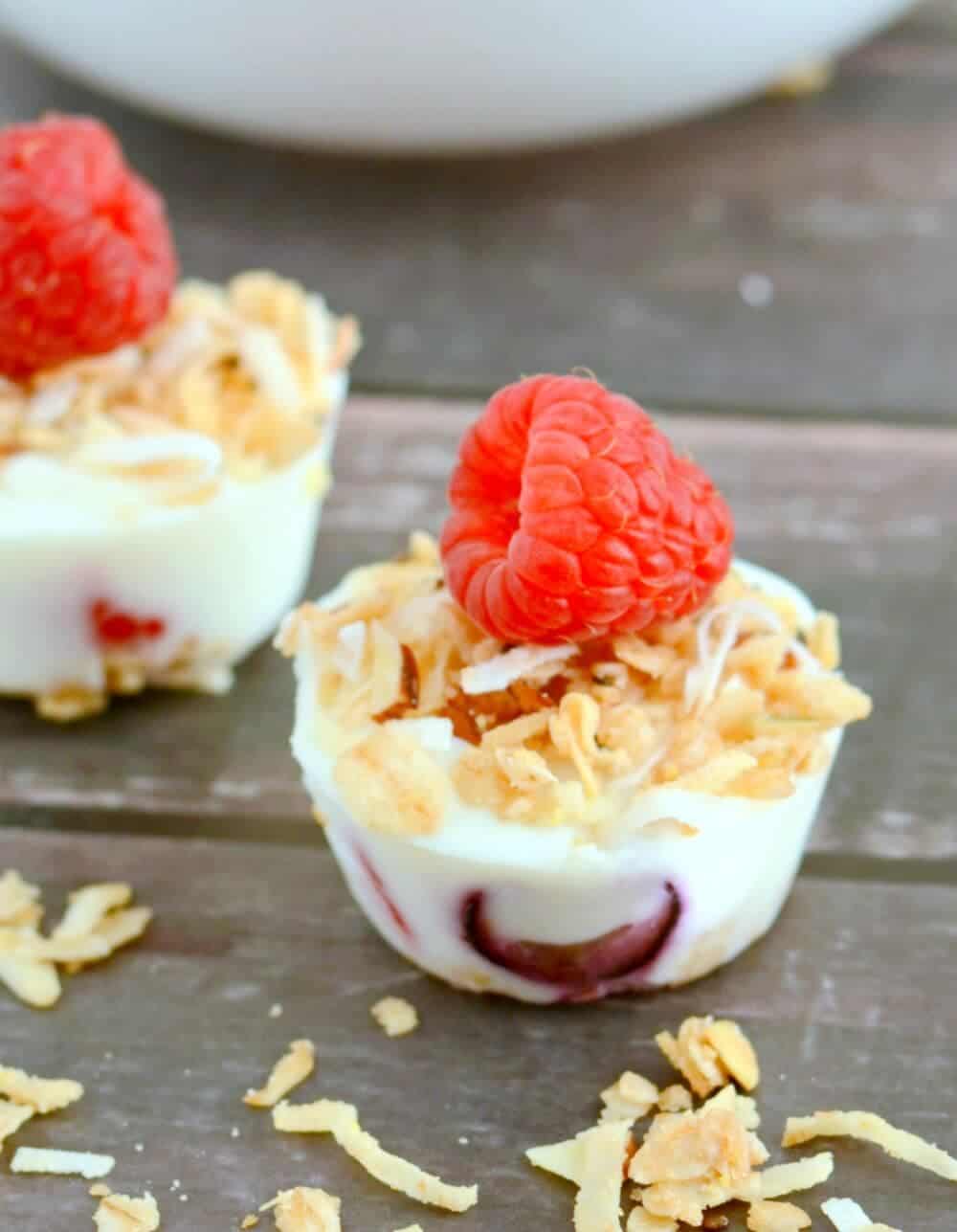 Granola yogurt bite with a fresh raspberry on top.