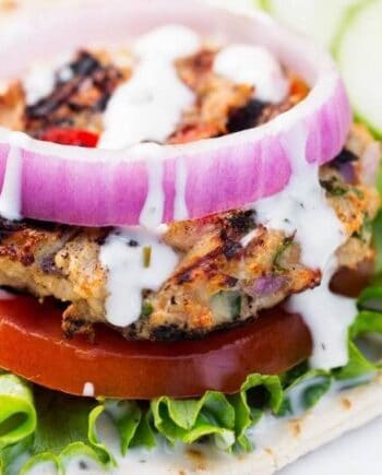 greek chicken burger with lettuce, tomato and onion