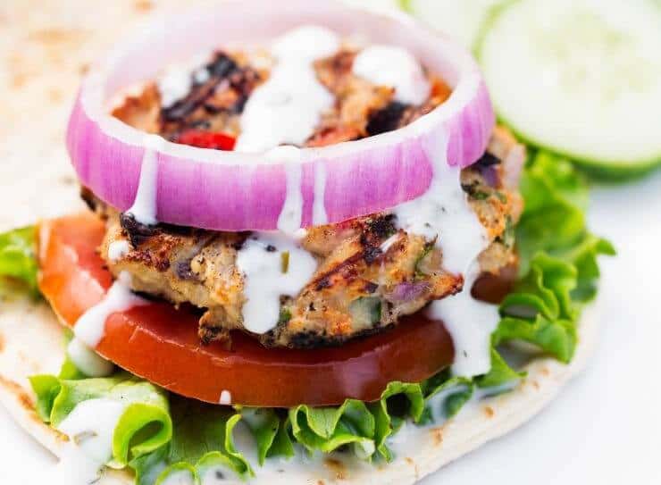 greek chicken burger with lettuce, tomato, red onion and tzatziki