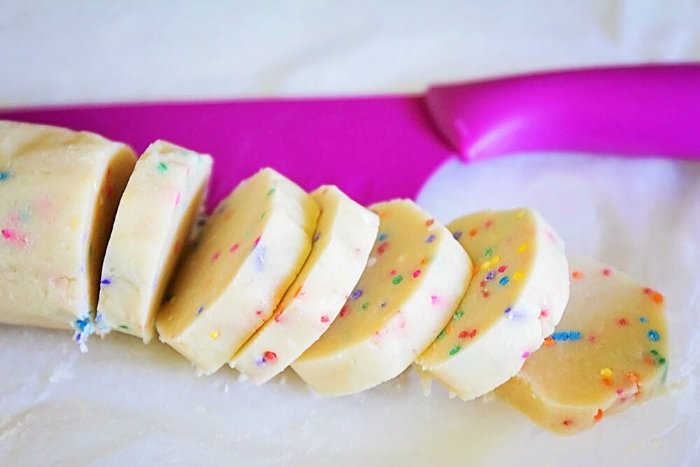 Slicing a sugar cookie log.