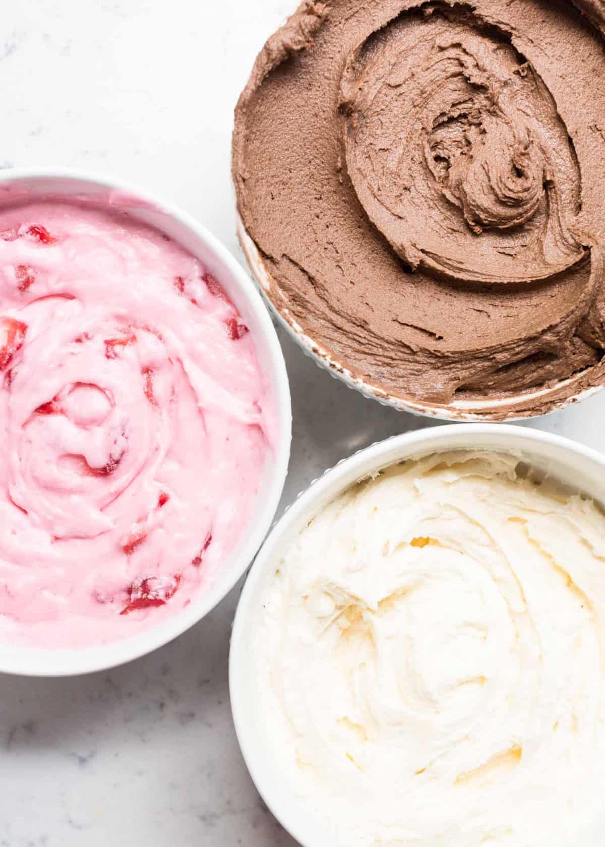 3 bowls with classic, chocolate and strawberry buttercream frosting 