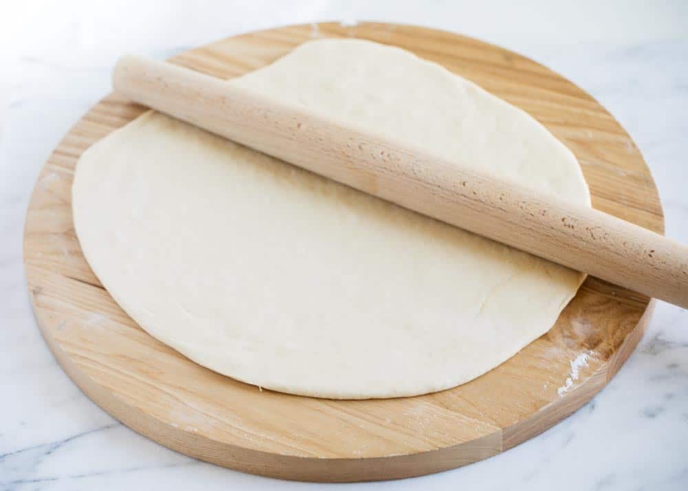 pizza dough being rolled out