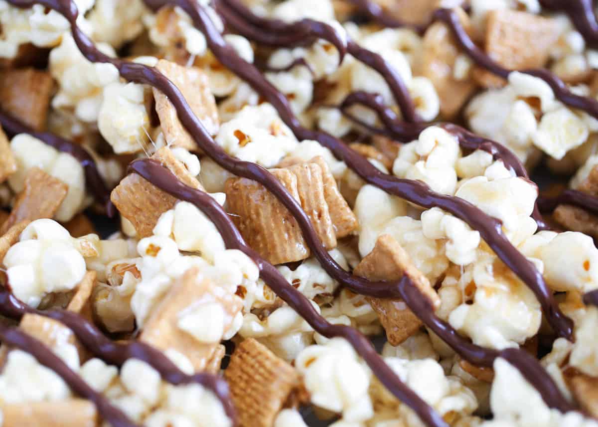 This s'mores popcorn mix is made with gooey marshmallows, crunchy Golden Grahams cereal and a sweet chocolate drizzle. It's the perfect easy dessert to make for your next movie night or get together with friends! s'mores popcorn drizzled with chocolate
