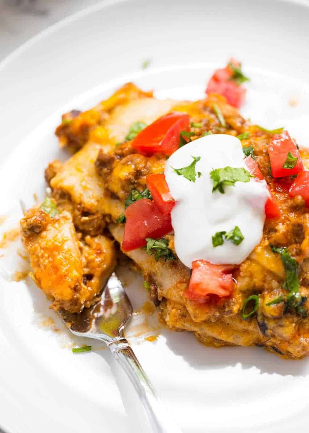 Slice of taco lasagna on a white plate.