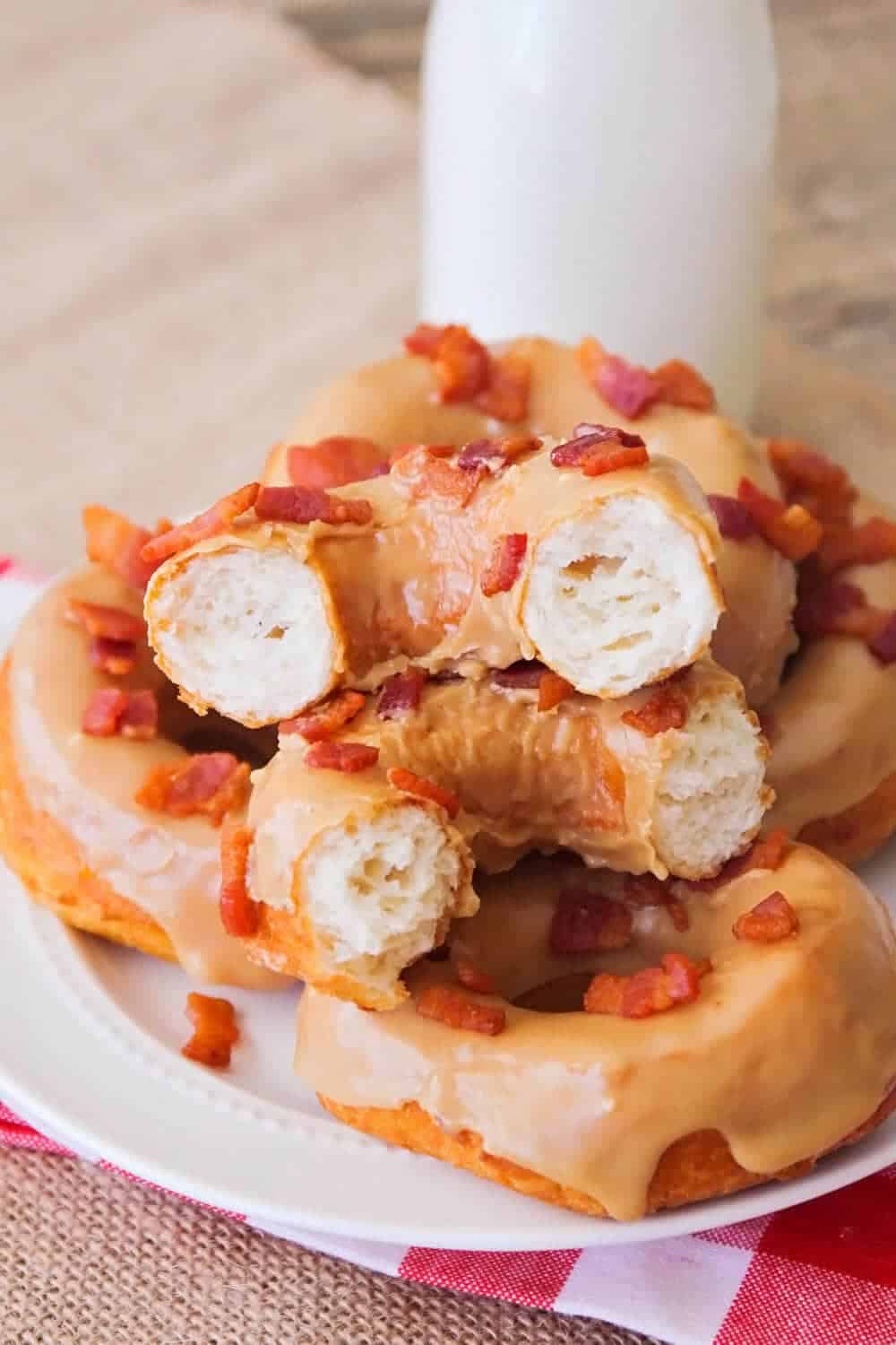 stack of maple bacon donuts on a white plate 