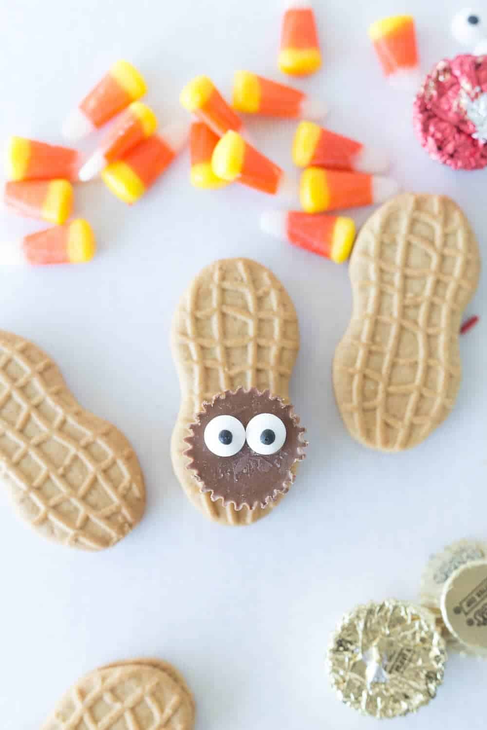 adding candy eyes on top of thanksgiving turkey cookies 