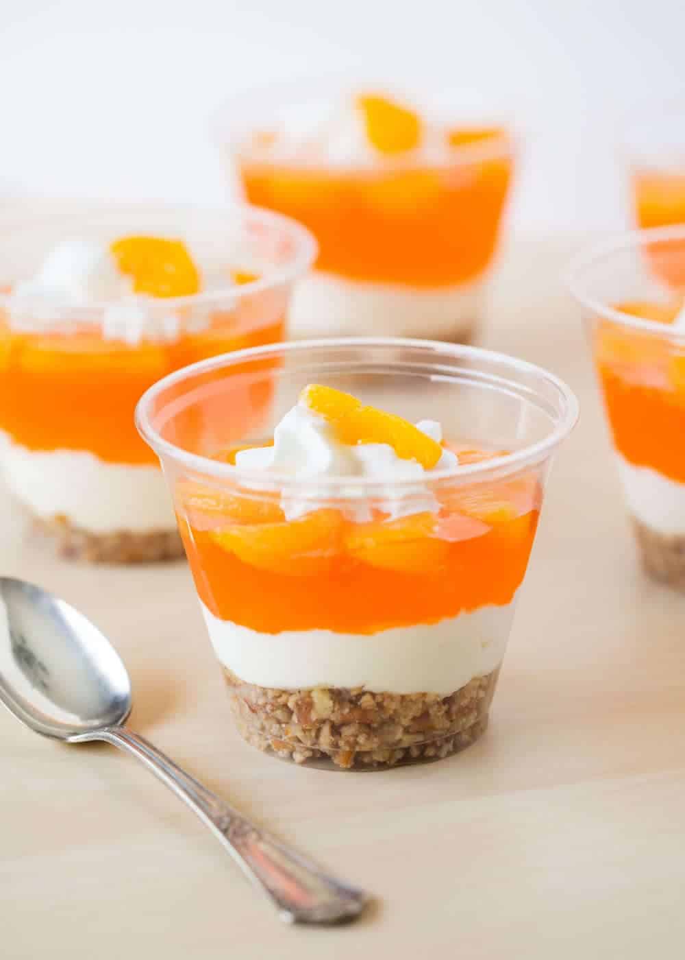 Mandarin orange pretzel parfait in a cup on the counter.