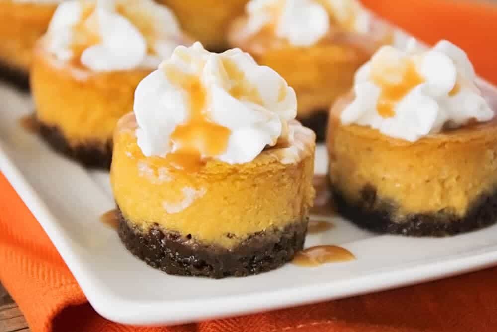 Mini pumpkin cheesecakes on plate.