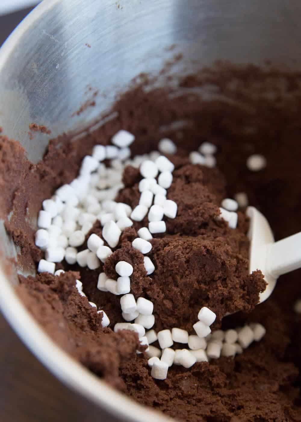 folding mini marshmallows into hot cocoa cookie batter 