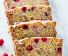 Cranberry Banana Bread... filled with white chocolate chips and topped with a powdered sugar glaze. So soft and full of flavor!