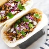 carnitas tacos on a taco holder stand