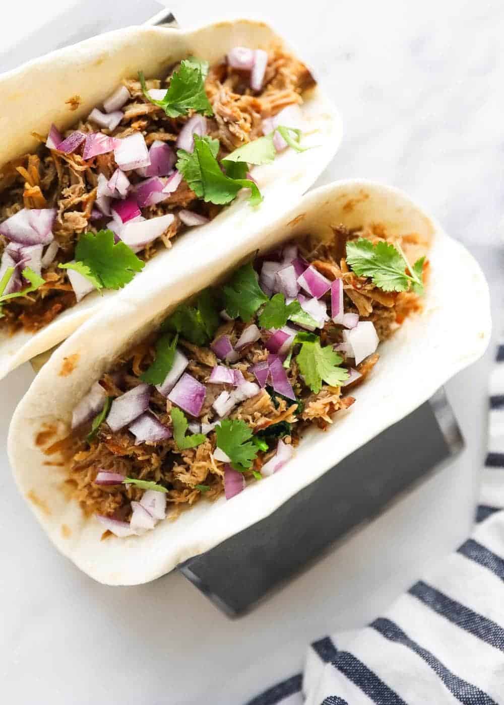 carnitas tacos on a taco holder stand 