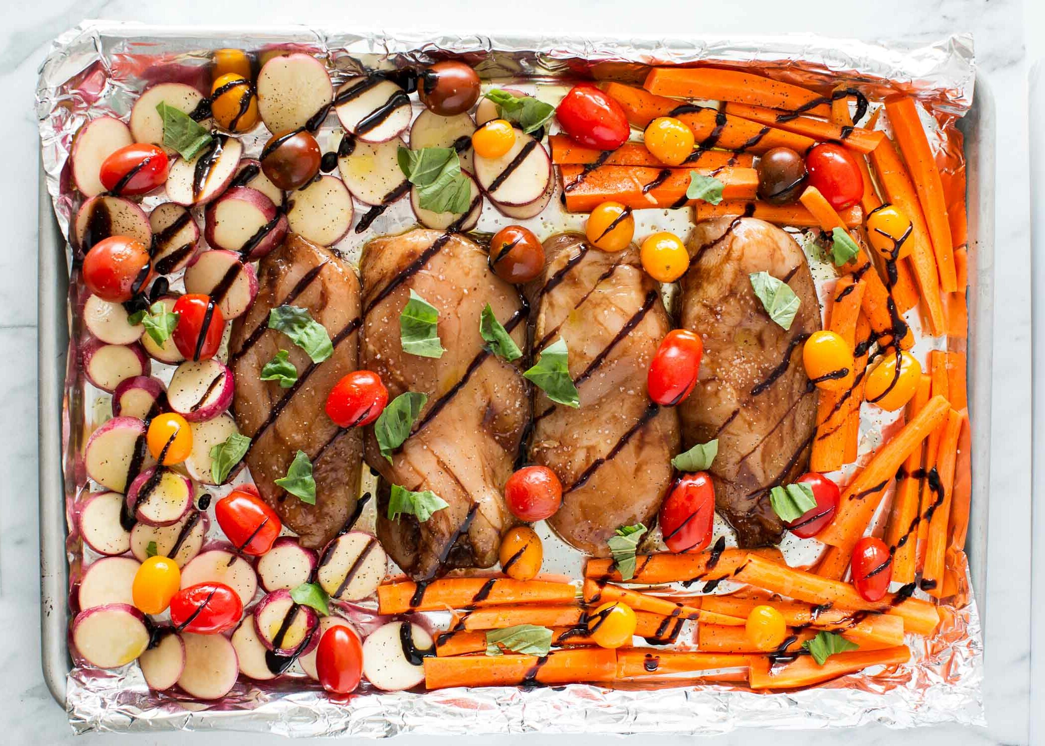 Balsamic chicken and vegetables on sheet pan lined with foil.