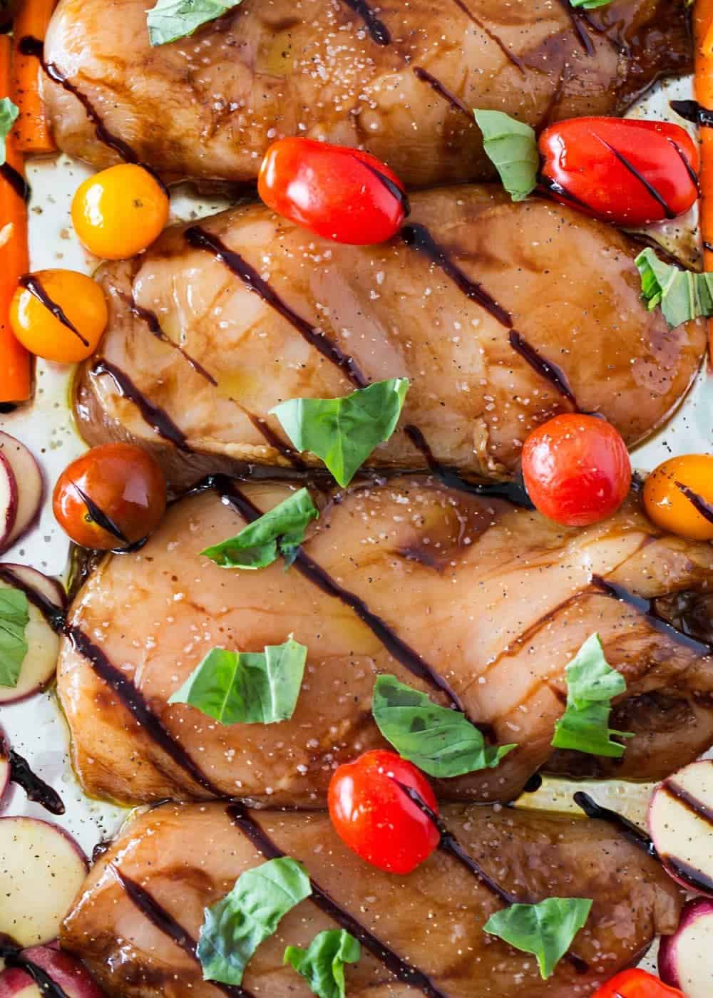 Close up of balsamic chicken with cherry tomatoes and fresh basil.