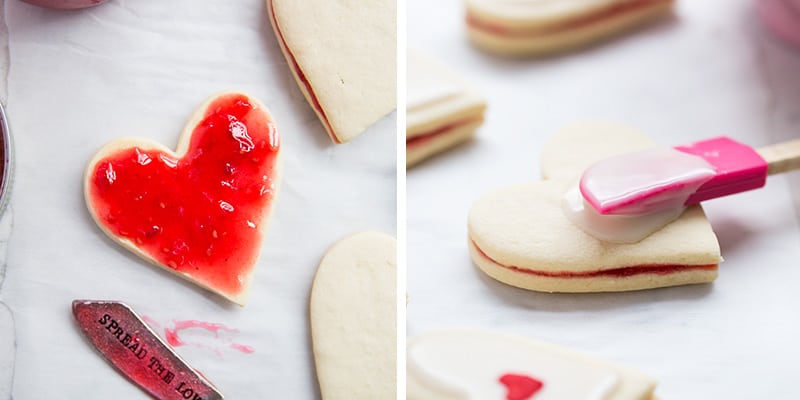 Spreading jam onto heart shaped cookie.