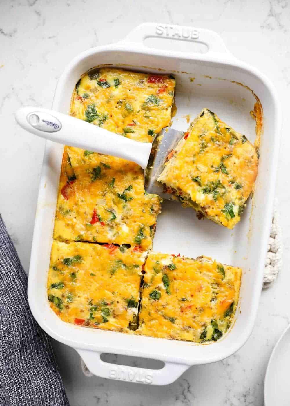 Breakfast casserole cut into squares in pan.