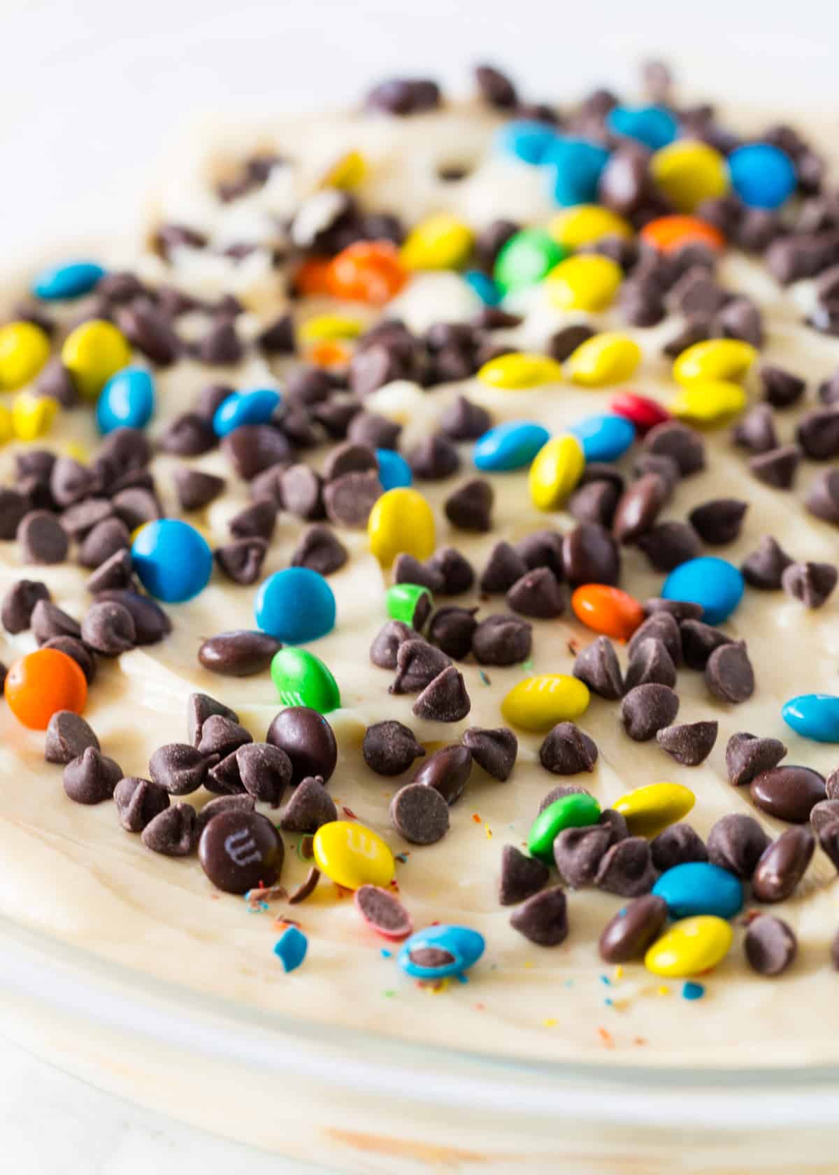 Chocolate chip cheesecake dip in glass pan.