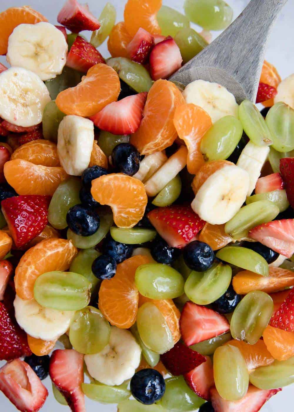 Fruit salad with wooden spoon.