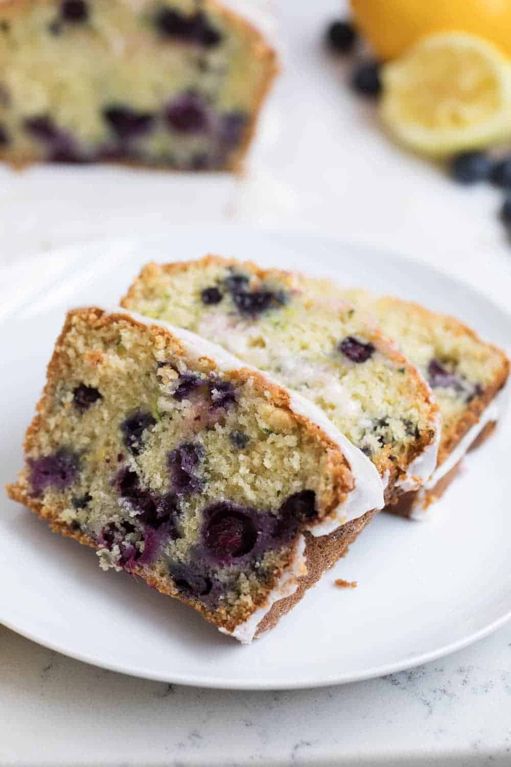 Slices of blueberry zucchini bread on a white plate.