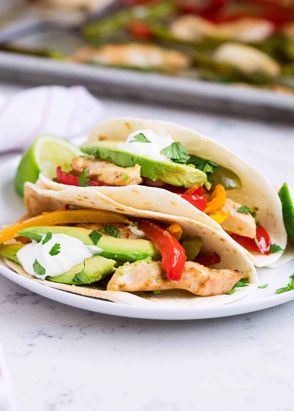 Plate of chicken fajitas in tortillas.