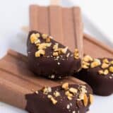 stack of fudge popsicles dipped in chocolate and crushed nuts