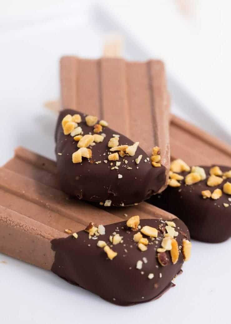 stack of fudge popsicles dipped in chocolate and crushed nuts 