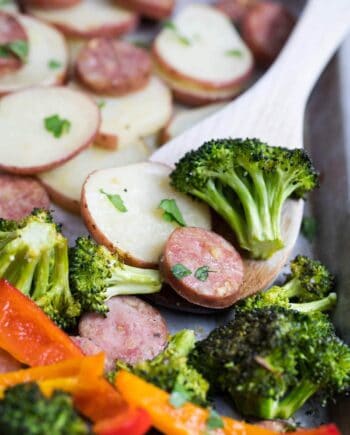 roasted sausage and veggies on a wooden spoon