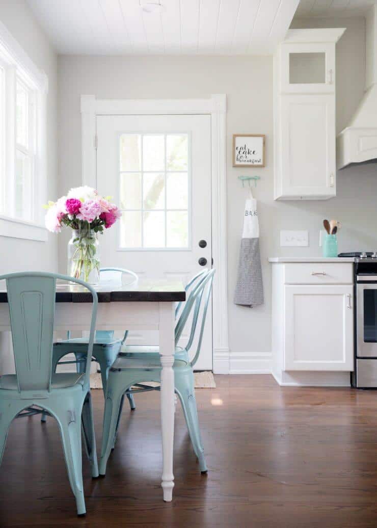 a kitchen table with a vase of flowers on top 