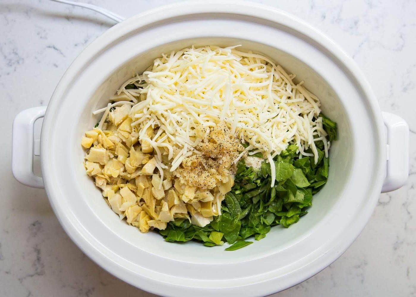 Ingredients for spinach artichoke dip in the crockpot.