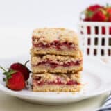 stack of strawberry crumb bars on a white plate