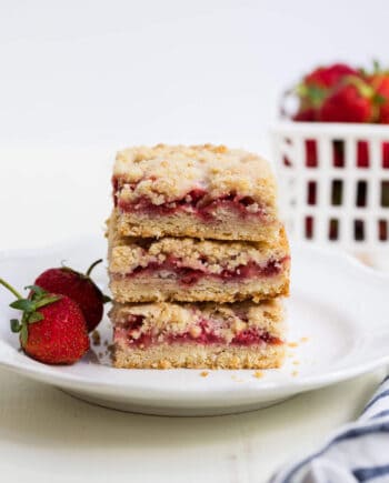 stack of strawberry crumb bars on a white plate